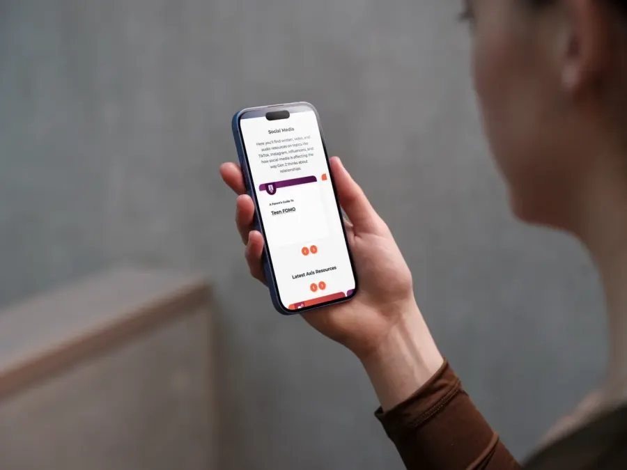 A parent reading Axis resources on a phone